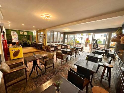 - un restaurant avec des tables, des chaises, des tables et des fenêtres en bois dans l'établissement Costa Maris Beach Hotel Frente Mar, à Guarujá