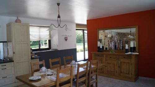 a dining room with a table and a mirror at À L'orée Du Bois in Pommerit-le-Vicomte