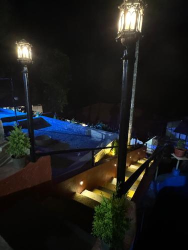 two street lights on a balcony at night at Coorg Heritage Hill View Resort in Madikeri