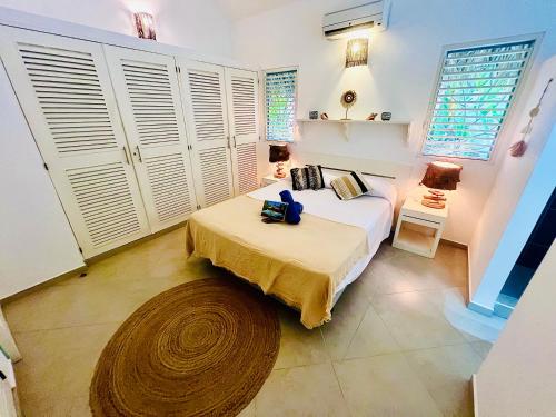 a bedroom with a bed and a room with windows at Villa Clarissa No. 8 in Las Terrenas
