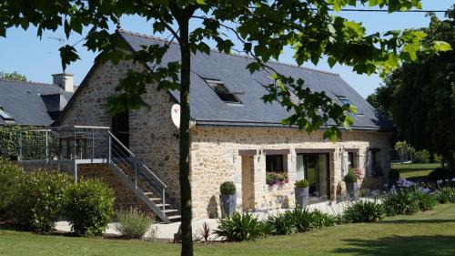 a brick house with a staircase in front of it at À L'orée Du Bois in Pommerit-le-Vicomte