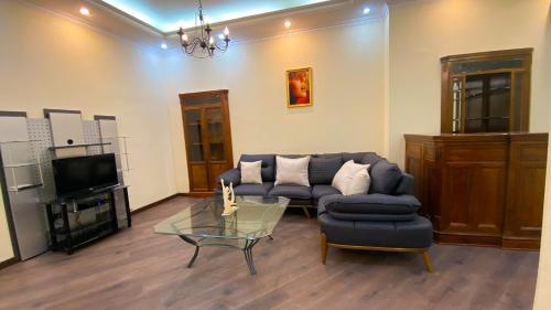 ein Wohnzimmer mit einem Sofa und einem Glastisch in der Unterkunft Charming Apart City Center in Baku