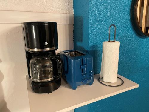 a coffee maker on a shelf next to a roll of paper towels at Vénosc-Les 2 Alpes , Rez de jardin in Vénosc