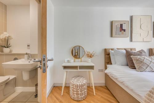 um quarto com uma cama, um lavatório e um espelho em Stunning City Centre Apartment with Balcony, Free Parking, Fast Wifi and SmartTVs by Yoko Property em Milton Keynes