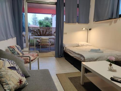 a bedroom with two beds and a living room with a table at Pool Seaside Relais - VILLE Ninfea, Marea, Rosa e Cassiopea in Fontane Bianche
