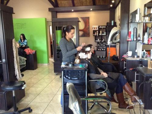a woman cutting a mans hair in a barber shop at 12 On Vaal Drive Guesthouse in Vanderbijlpark