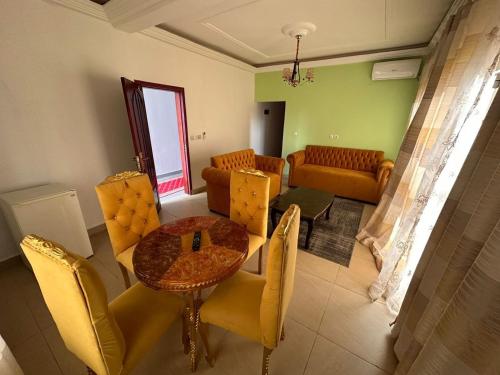 uma sala de estar com mesa e cadeiras em SEGMAD HOTEL em Kribi