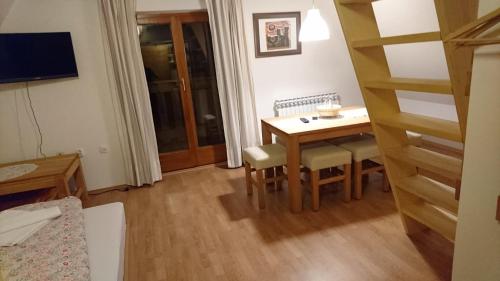 a small room with a table and chairs and a staircase at Apartmani Nono in Jahorina