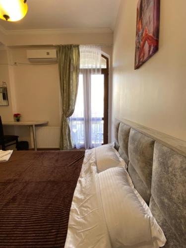 a large bed in a room with a window at Siqvaruli in Tbilisi City