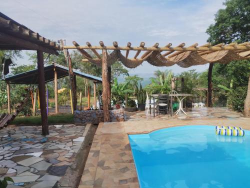 - une piscine dans un jardin avec une pergola dans l'établissement Pousada Pôr do Sol, à Uberlândia