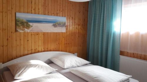 a bed with two pillows and a picture of a beach at Ferienwohnung Alona in Garz
