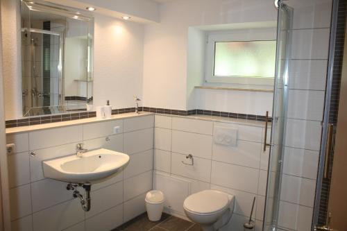 a white bathroom with a sink and a toilet at Ferienwohnung Alona in Garz