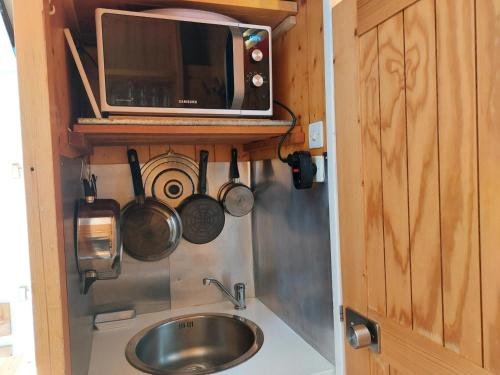 une cuisine avec un évier et un micro-ondes dans l'établissement Résidence Nova - Studio pour 2 Personnes 11, à Arc 1800