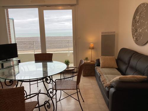 un salon avec une table en verre et un canapé dans l'établissement Le Sémaphore, à Cayeux-sur-Mer