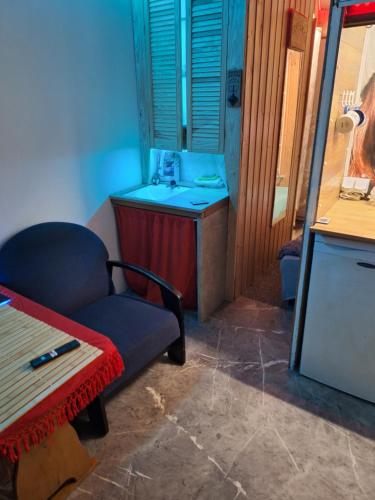 ein Wohnzimmer mit einem Stuhl und einem Waschbecken in der Unterkunft Szalupa H9 in Zakroczym