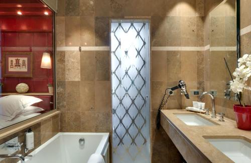 a bathroom with two sinks and a tub at Hôtel du Château & Spa - Teritoria in Carcassonne