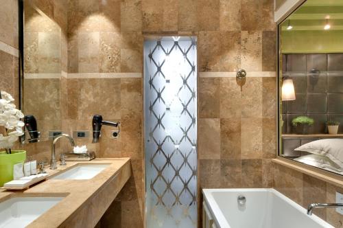 a bathroom with two sinks and a shower at Hôtel du Château & Spa - Teritoria in Carcassonne