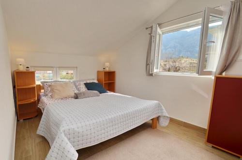 a white bedroom with a bed and a window at La Mar Mar in Kotor
