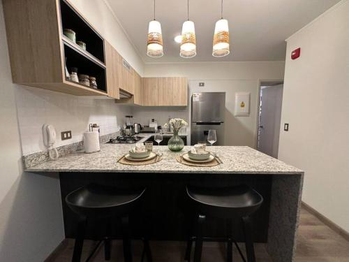 a kitchen with a counter with two stools at it at San Isidro Estreno Luxury Apart Pool Gym 804SI in Lima