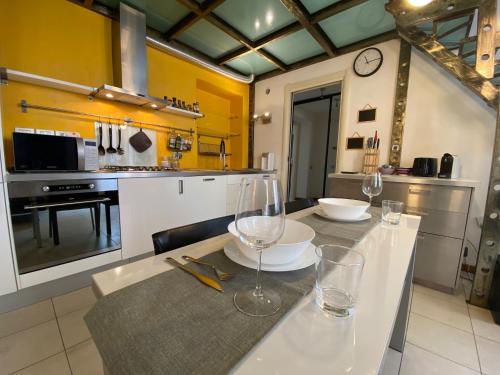 a kitchen with a table with wine glasses on it at Appartamento Al Teatro in Livorno