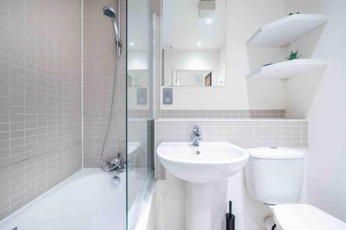 a bathroom with a sink and a toilet and a shower at Stylish 1 BR Apartment Near Shoreditch - 10 Min Walk in London