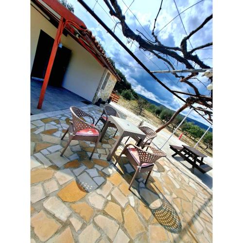 a patio with chairs and a table on a stone floor at ANDRIA in Peristerona