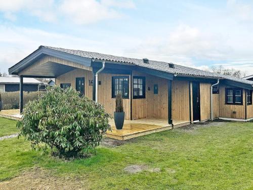 ein kleines Haus mit einer Veranda und einem Hof in der Unterkunft 4 person holiday home in Juelsminde in Juelsminde
