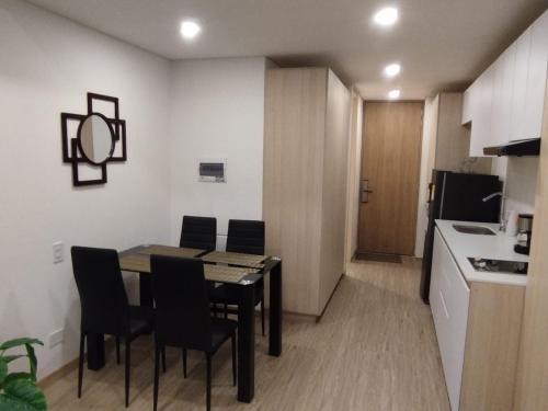 a small kitchen and dining room with a table and chairs at Solar apartaestudio facic in Chía