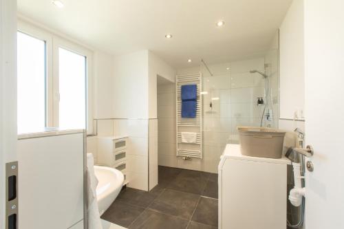 a white bathroom with a tub and a sink at Authi's Charmante Stube in Kirchheim unter Teck