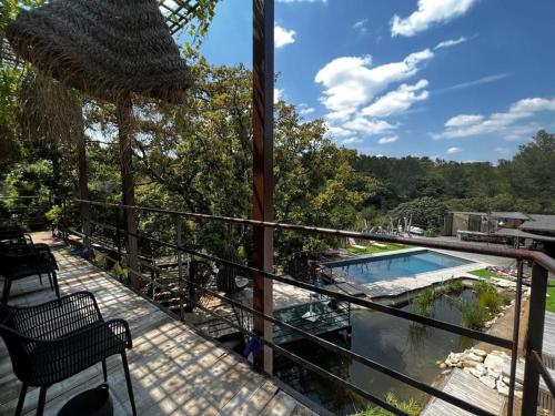un balcon avec vue sur une piscine dans l'établissement La Villa Bali *****, à Nîmes
