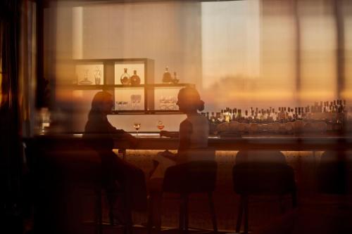 two people sitting at a bar looking out a window at The Ritz-Carlton, Perth in Perth