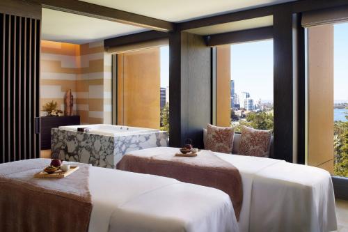 a hotel room with three beds and a window at The Ritz-Carlton, Perth in Perth