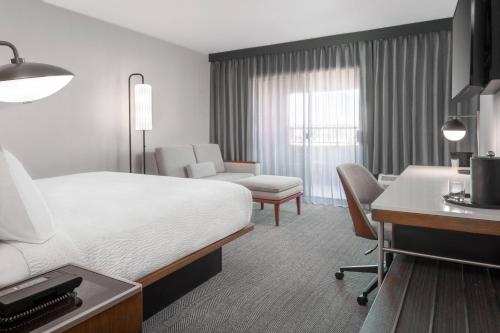 a hotel room with a bed and a desk at Courtyard Farmington in Farmington