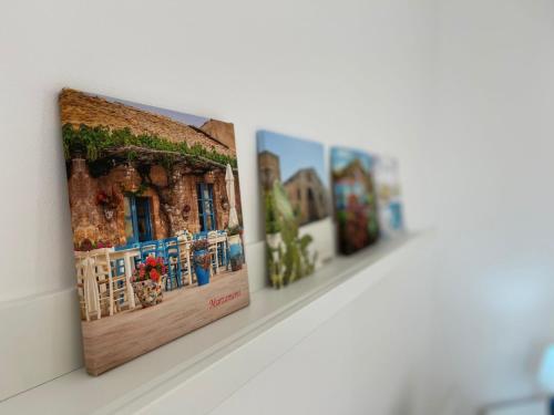 a row of photographs on a display shelf in a museum at Casa Vacanze Matilde Marzamemi in Marzamemi