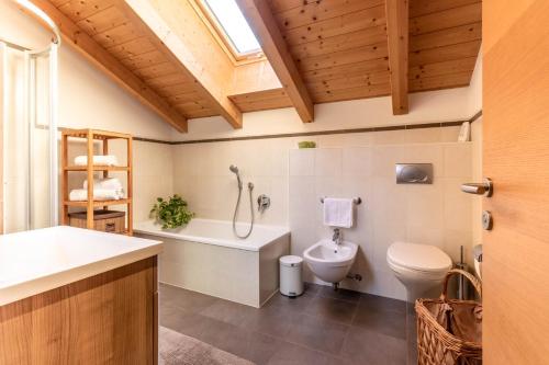 La salle de bains est pourvue de toilettes, d'une baignoire et d'un lavabo. dans l'établissement Ferienwohnung am Zehenthof, à San Giovanni