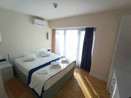 a bedroom with a bed and a large window at Orbi city Panorama towers in Batumi