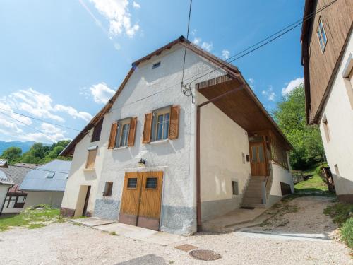 un edificio blanco con puertas de madera y una escalera en Apartma Florent, en Bovec