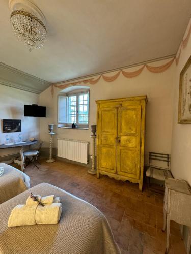- une chambre avec 2 lits et une commode en bois dans l'établissement Casale San Giorgio, à Luco di Mugello
