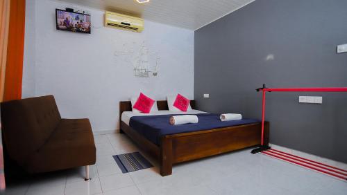 a bedroom with a bed and a chair in it at Andorra Tourist Resort Anuradhapura in Anuradhapura