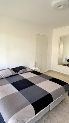 - un grand lit noir et blanc dans une chambre dans l'établissement Studio Carré d'Or, à Nice