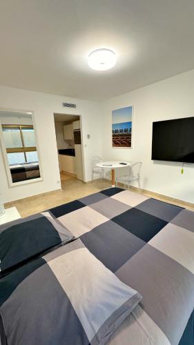 une chambre avec un grand lit avec une télévision à écran plat dans l'établissement Studio Carré d'Or, à Nice