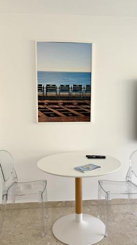 une table et des chaises dans une pièce avec une photo sur le mur dans l'établissement Studio Carré d'Or, à Nice