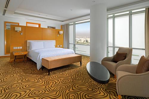 a hotel room with a bed and two chairs at Le Meridien Cairo Airport in Cairo