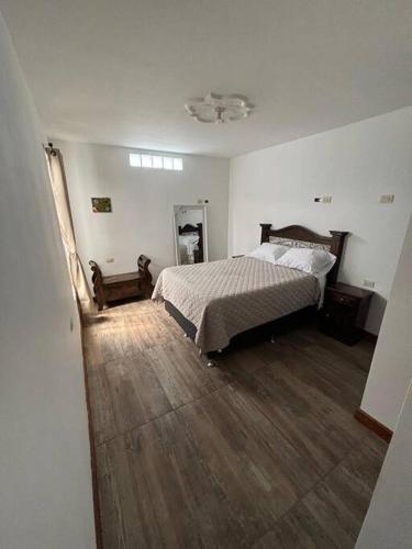 - une chambre avec un lit et du parquet dans l'établissement Refugio colonial y acogedor., à San Miguel Morazán