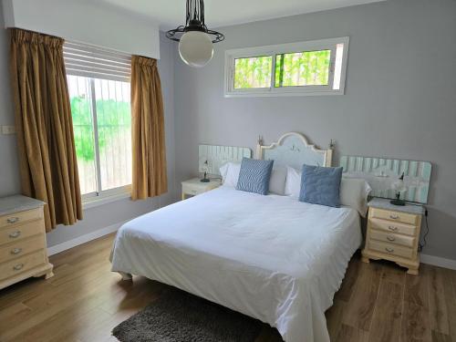 een slaapkamer met een wit bed en 2 ramen bij Apartamento Drago in Santa Cruz de Tenerife