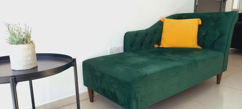 a green couch with a yellow pillow next to a table at Trendy Holiday Villa 38 Larnaca, Pyla in Larnaka