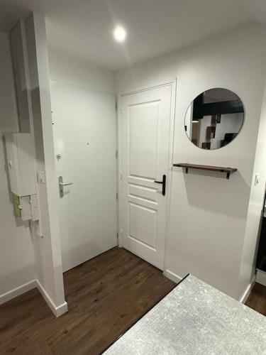 a white room with a door and a mirror at Appartement 2 in Dunkerque
