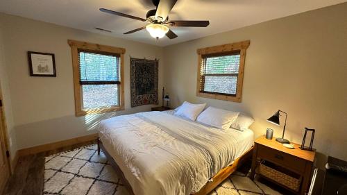 Schlafzimmer mit einem Bett und einem Deckenventilator in der Unterkunft Twinn Peaks Beautiful Modern Mountain Cabin Retreat-Cozy-Secluded-WiFi-Pets in Murphy