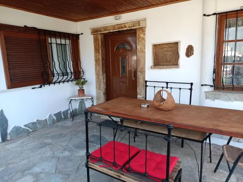 Habitación con mesa y sillas acolchadas de color rojo. en Stef Panorama House, en Loutraki