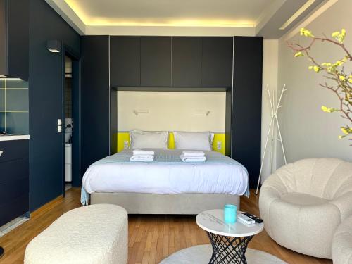 a bedroom with a bed and two chairs and a table at Cloud 9 - Smart apartment jacuzzi in Athens